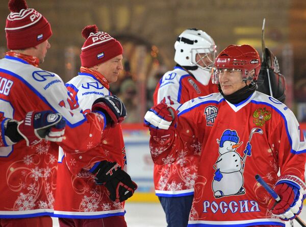 Vladimir Putin îi întâmpină pe jucători înaintea începerii meciului amical de hochei nocturn de Anul Nou, la patinoarul din Piața Roșie. - Sputnik Moldova-România