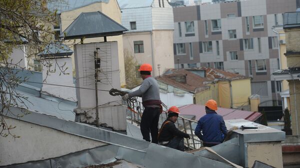 Рабочие-строители на крыше здания в Москве. - Sputnik Moldova
