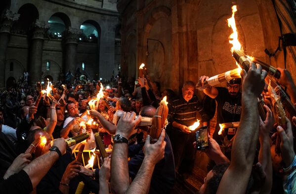 Верующие празднуют схождение Благодатного огня в храме Гроба Господня - Sputnik Moldova-România