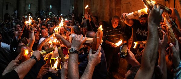 Верующие празднуют схождение Благодатного огня в храме Гроба Господня - Sputnik Moldova-România