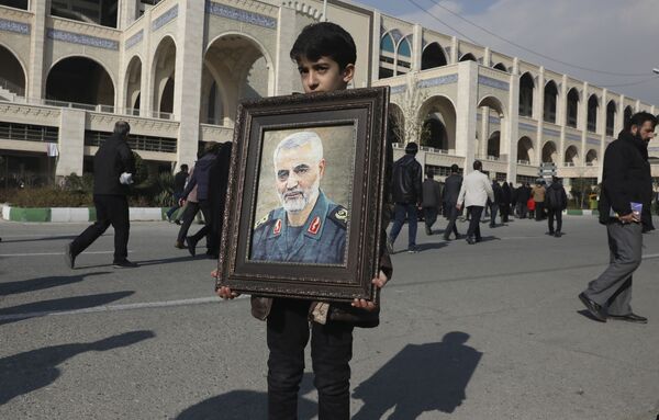 Мальчик держит портрет убитого генерала Сулеймани - Sputnik Молдова