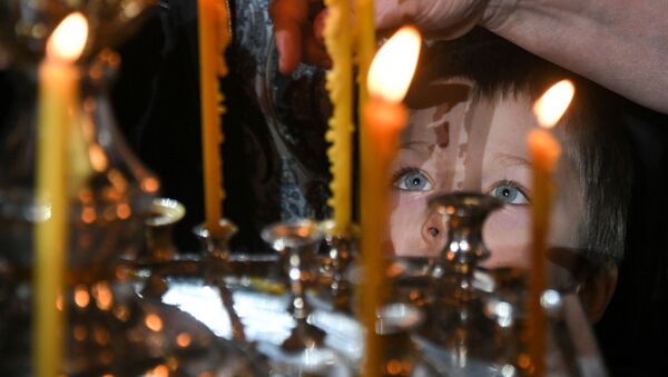 Ребенок во время Рождественского богослужения в храме Христа Спасителя в Москве - Sputnik Молдова