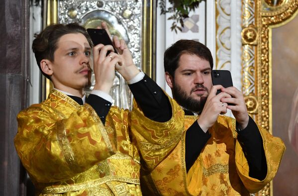 Православные служки фотографируют во время Рождественского богослужения в храме Христа Спасителя в Москве - Sputnik Молдова