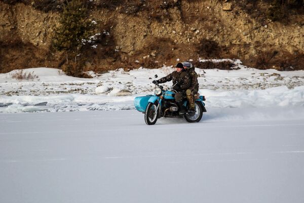 Местные жители едут на мотоцикле по берегу озера Байкал - Sputnik Молдова