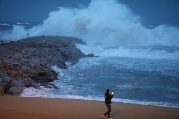 Мужчина фотографирует шторм Глория на пляже Барселонета в Барселоне, Испания - Sputnik Молдова