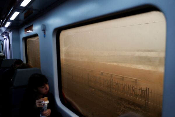 Пассажир смотрит на море во время поездки на поезде во время шторма Глория на побережье Маресме, недалеко от Барселоны, Испания - Sputnik Молдова