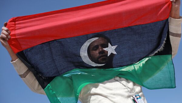 Житель Бенгази с флагом Ливии. Архивное фото - Sputnik Молдова