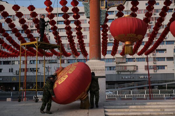 Рабочие демонтируют украшения после решения об отмене ярмарки для празднования лунного нового года в Пекине, Китай - Sputnik Молдова