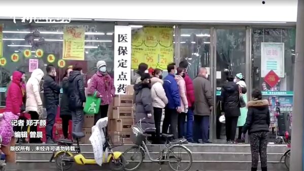 Люди в защитных масках стоят в очереди в магазин в Ухане, Китай - Sputnik Молдова