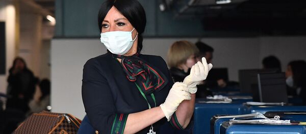  Сотрудница в защитных перчатках и маске при подготовке к регистрации пассажиров у стойки авиакомпании China Southern Airlines в римском аэропорту Фьюмичино  - Sputnik Moldova-România