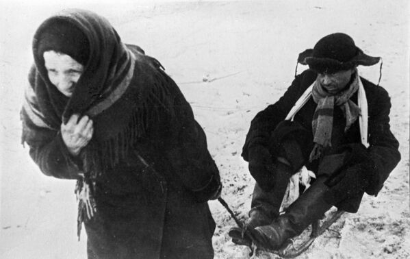 Женщина везет ослабевшего от голода мужа в дни блокады Ленинграда - Sputnik Moldova-România