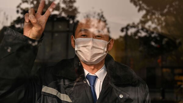 Охранник отеля в маске в китайском городе Ухань  - Sputnik Moldova