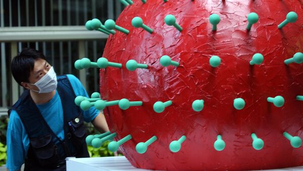 Человек в маске смотрит на модель коронавируса SARS в мэрии в Тайбэе - Sputnik Молдова