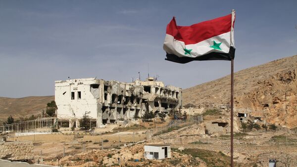 Сирийский флаг на фоне разрушенного дома в сирийском городе Маалюля - Sputnik Moldova