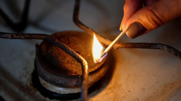 Женщина зажигает конфорку газовой плиты в жилом доме, архивное фото. - Sputnik Молдова