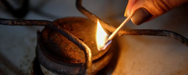 Женщина зажигает конфорку газовой плиты в жилом доме - Sputnik Молдова