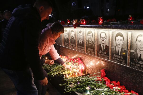 Люди возлагают цветы и зажигают свечи во время проведения акции памяти ликвидаторов и жертв аварии на Чернобыльской атомной электростанции в городе Славутич - Sputnik Молдова