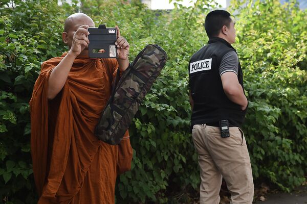 Монах снимает на телефон ситуацию у торгового центра Terminal 21, где произошла стрельба в Таиланде  - Sputnik Молдова