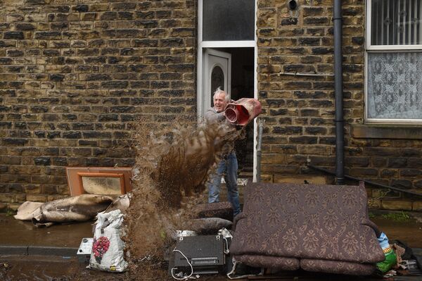 Мужчина чистит дом после наводнения в Северной Англии. - Sputnik Молдова