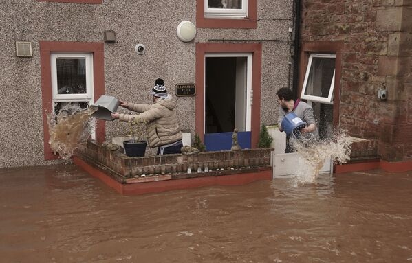 Мужчины вычерпывают воду из затопленного дома. - Sputnik Молдова