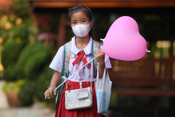 Школьница в медицинской маске и с воздушным шаром  в День святого Валентина в одной из школ города Аюттхая, Таиланд - Sputnik Молдова