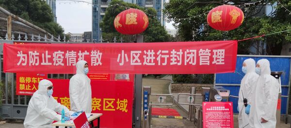 Workers in protective suits are seen at a checkpoint for registration and body temperature measurement, at an entrance to a residential compound in Wuhan, February 13, 2020 - Sputnik Moldova-România