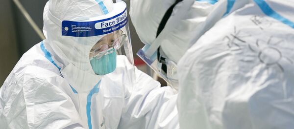 Медицинские работники в защитной одежде у пациента с коронавирусом в больнице Уханьского университета - Sputnik Moldova-România