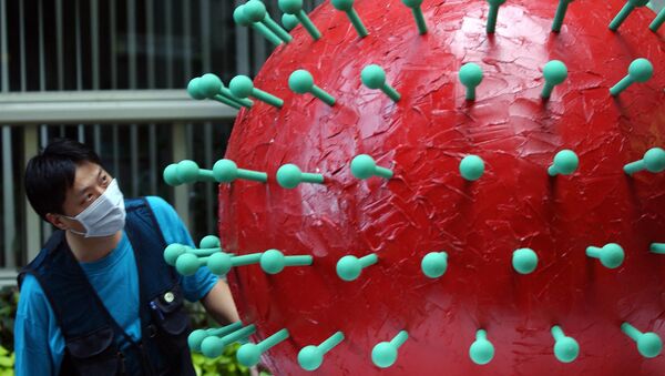 Человек в маске смотрит на модель коронавируса SARS в мэрии в Тайбэе - Sputnik Moldova