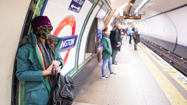 Девушка в защитной маске на платформе метро в Лондоне - Sputnik Молдова