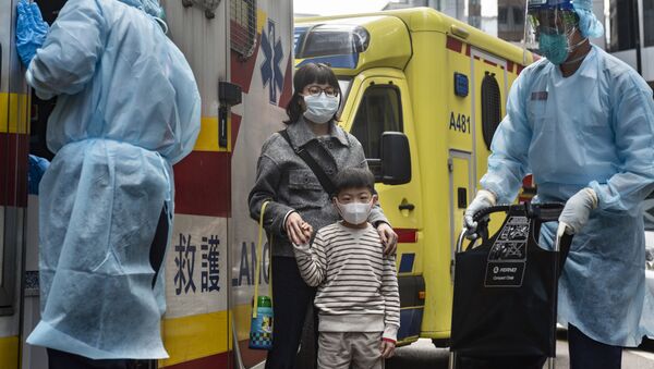Женщина с ребенок в защитных масках рядом с автомобилем скорой помощи на одной из улиц в Гонконге. - Sputnik Молдова