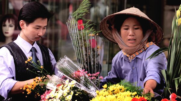 Tânăr vietnamez cumpărând trandafiri în cartierul vechi din Hanoi, Vietnam - Sputnik Moldova