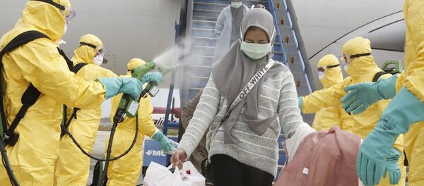 Индонезийцы, прибывшие из Уханя, Китай, получают антисептическое средство в аэропорту Ханг Надим в Батаме - Sputnik Молдова