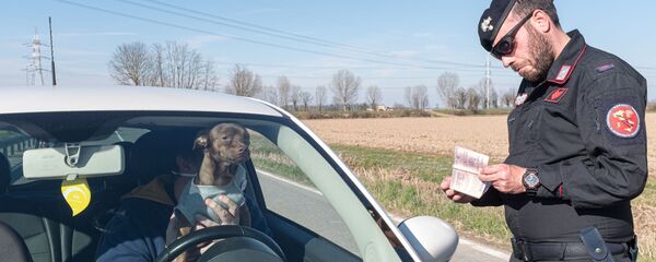 Carabinier verifică actele unui bărbat care poartă o mască de protecție într-o mașină la punctul de control din San Fiorano - Sputnik Moldova