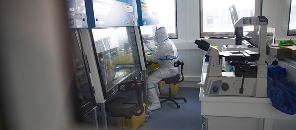 Оператор лаборатории, носящий защитное снаряжение, проводит испытания в исследовательской лаборатории Оператор лаборатории, носящий защитное снаряжение, проводит испытания в исследовательской лаборатории - Sputnik Moldova