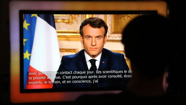 French President Emmanuel Macron is seen on a television screen as he speaks during a televised address to the nation on the outbreak of COVID-19, caused by the novel coronavirus, on March 16, 2020, in Paris - Sputnik Moldova-România