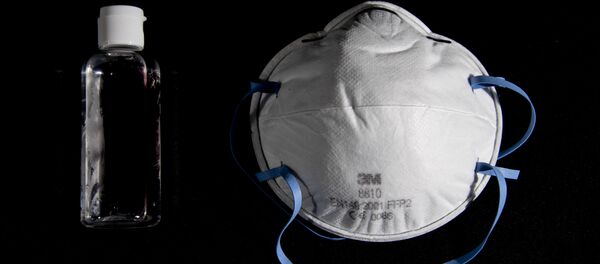  Бутылка дезинфицирующего средства для рук с спиртосодержащим гелем и защитная маска для лица  - Sputnik Moldova