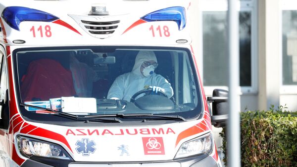 Un lucrător medical în costum de protecție conduce o ambulanță - Sputnik Moldova