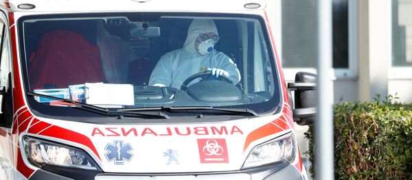 Un lucrător medical în costum de protecție conduce o ambulanță Un lucrător medical în costum de protecție conduce o ambulanță - Sputnik Moldova-România