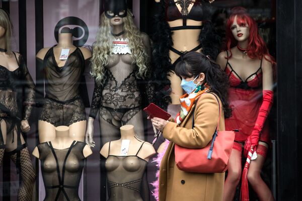 Женщина в медицинской маске на фоне витрин в Париже - Sputnik Молдова
