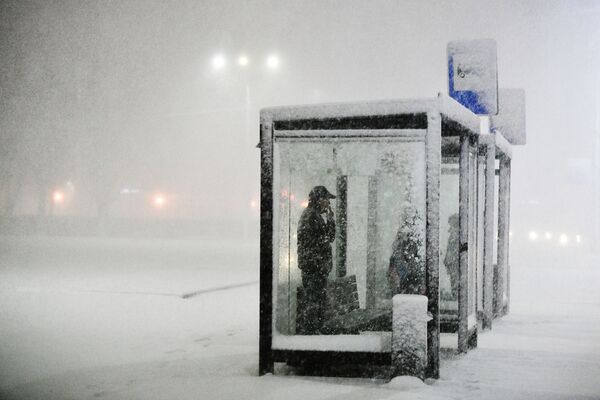 Люди на остановке общественного транспорта во время снегопада в Подольске - Sputnik Молдова