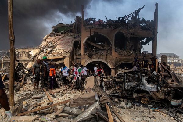 Представители Красного Креста выносят жертву взрыва газа из пострадавшего здания в Лагосе, Нигерия - Sputnik Молдова