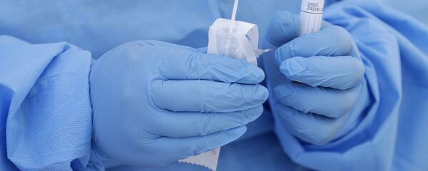 Медицинский работник показывает упакованный мазок из носоглотки для тестирования Медицинский работник показывает упакованный мазок из носоглотки для тестирования - Sputnik Moldova