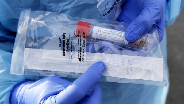 Медицинский работник показывает упакованный мазок из носоглотки для тестирования COVID-19  - Sputnik Молдова