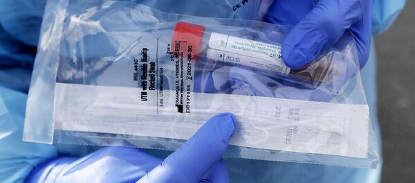 Медицинский работник показывает упакованный мазок из носоглотки для тестирования COVID-19 Медицинский работник показывает упакованный мазок из носоглотки для тестирования COVID-19 - Sputnik Moldova