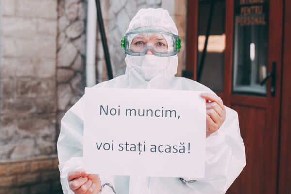 Медицинский работник в маске с обращением к гражданам Noi muncim, voi stați acasă! - Sputnik Молдова