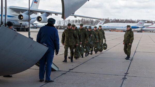 Военнослужащие медицинской службы ВС РФ во время посадки в военно-транспортный самолет ВКС России Ил-76 МД  - Sputnik Молдова