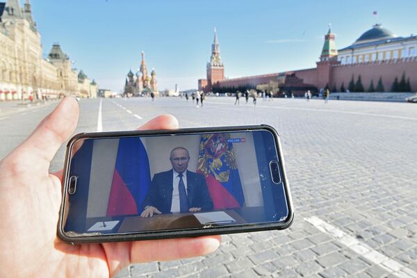Житель Москвы во время просмотра трансляции обращения президента России Владимира Путина к гражданам в связи с коронавирусом  - Sputnik Молдова