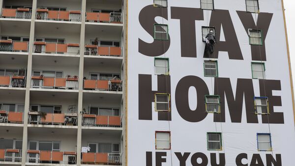 Рекламный плакат с призывом остаться дома на здании в Южной Африке  - Sputnik Молдова