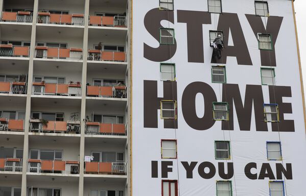 Рекламный плакат с призывом остаться дома на здании в Южной Африке  - Sputnik Молдова