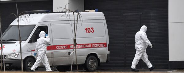 Сотрудники скорой помощи в защитных костюмах на территории больничного комплекса в Коммунарке - Sputnik Молдова